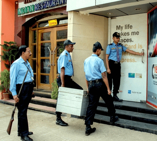 Armed Guard standing with Cash Van in  