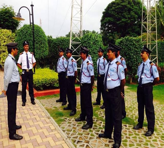 Industrial Security Guard standing with safety helmet outside manufacturing unit